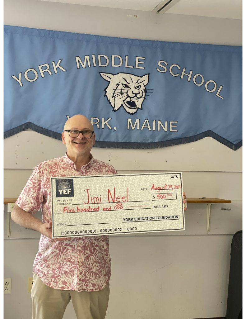 Jimi Neel holding the check he received for the 2025 Dr Henry R. Scipione Award